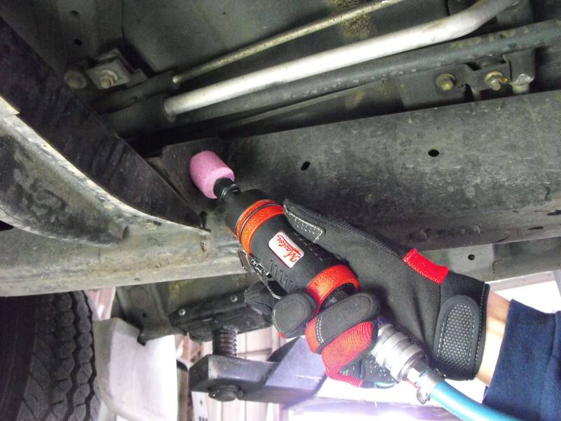 a mechanic working on a vehicle under a vehicle