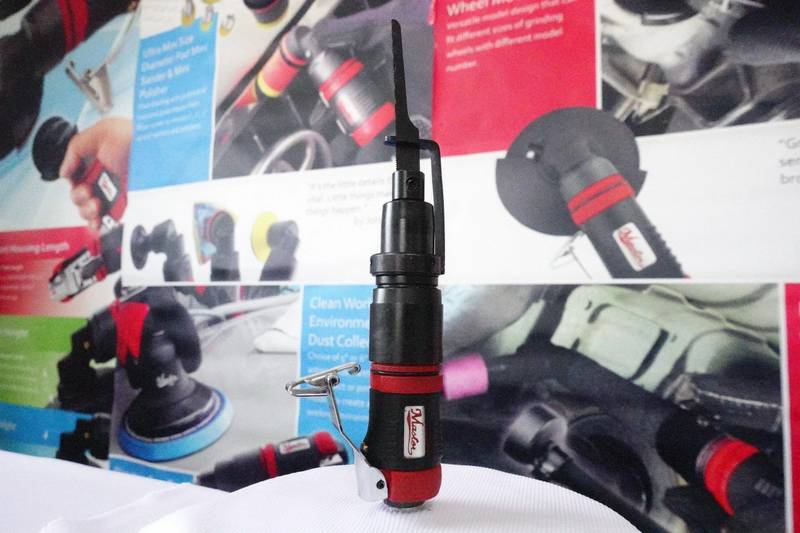 a red and black cordless drill is on a table